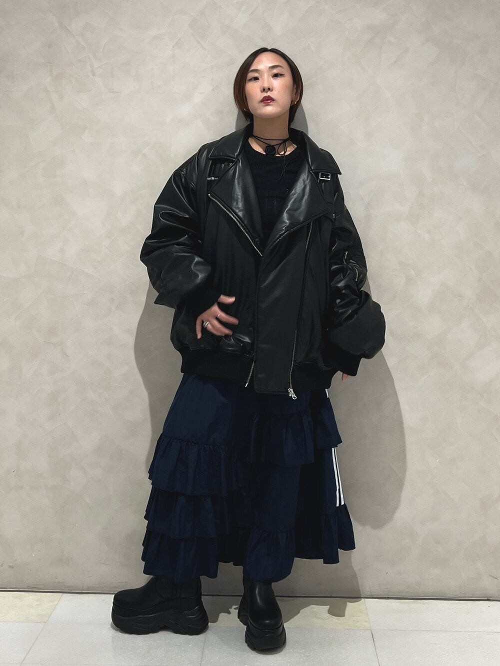 ブラック系のブルゾン、ブルー系のスカート、ブラック系のブーツを着用したレディースの秋コーディネートの4枚目の写真