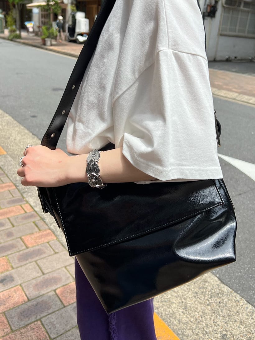 ブラック系のハンドバッグ、ホワイト系のTシャツ/カットソー、パープル系のデニムパンツを着用したレディースの夏コーディネートの10枚目の写真