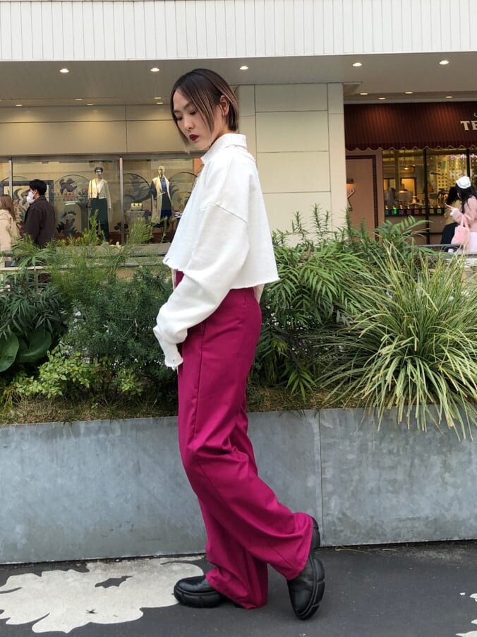 ピンク系のスラックス、ホワイト系のトートバッグ、ブラック系のブーツを着用したレディースの春コーディネートの3枚目の写真