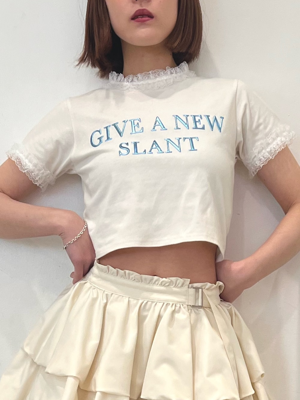ホワイト系のTシャツ/カットソー、ホワイト系のスカート、ブラック系のブーツを着用したレディースの春コーディネートの4枚目の写真