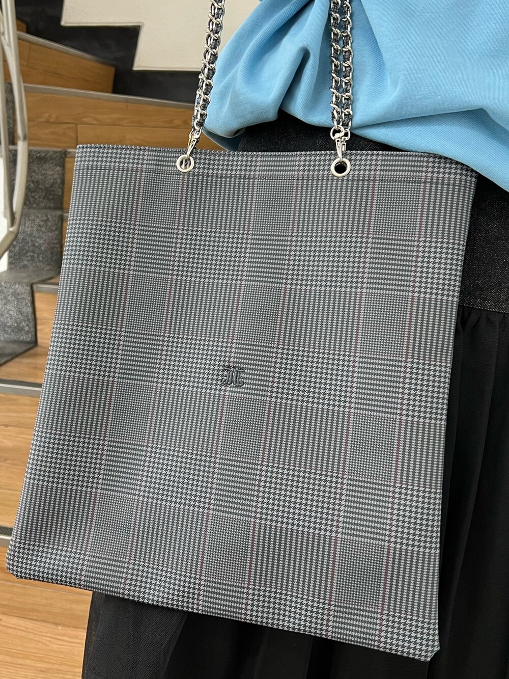 ブルー系のスウェット、ブラック系のスカート、グレー系のトートバッグを着用したレディースの冬コーディネートの10枚目の写真