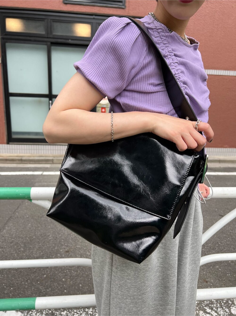 ブラック系のハンドバッグ、パープル系のTシャツ/カットソー、グレー系のその他パンツを着用したレディースの夏コーディネートの10枚目の写真