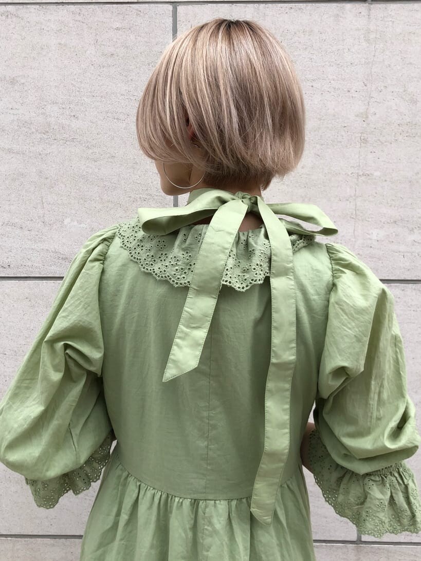 ブラック系のハンドバッグ、グリーン系のワンピース、シルバー系のチョーカーを着用したレディースの夏コーディネートの6枚目の写真