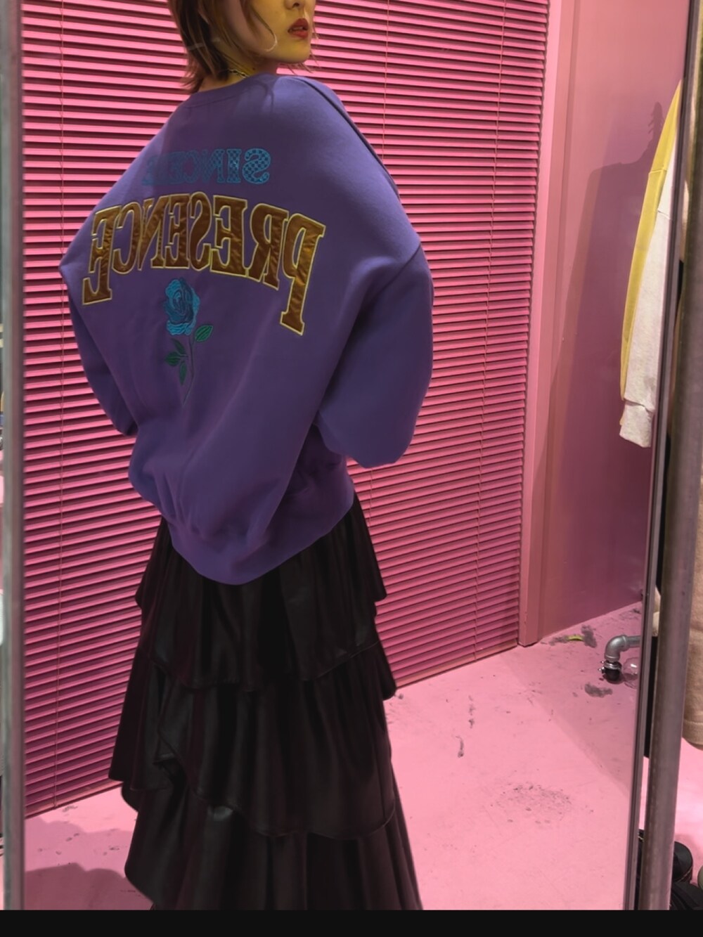 パープル系のTシャツ/カットソー、ブラック系のスカート、ブラック系のブーツを着用したレディースの秋コーディネートの4枚目の写真