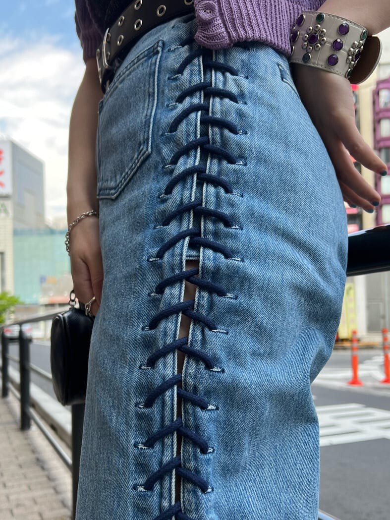 ブラック系のハンドバッグ、ブラック系のニット/セーター、ブルー系のデニムパンツを着用したレディースの夏コーディネートの7枚目の写真