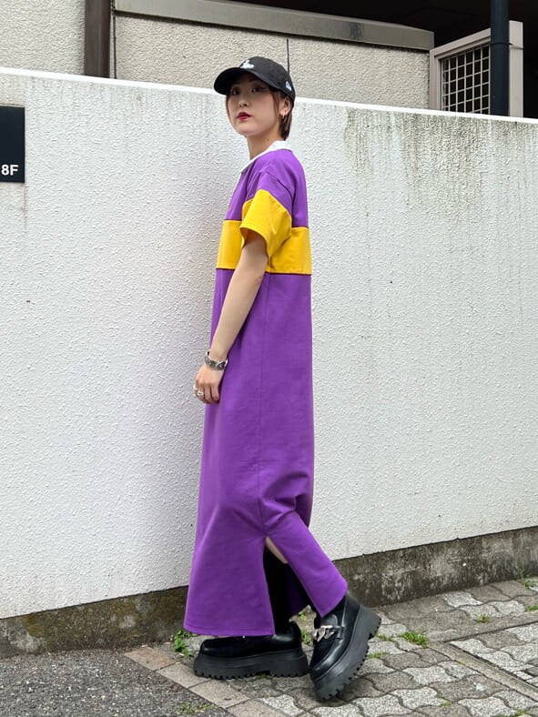 パープル系のワンピース、ブラック系のローファー、ブラック系のキャップを着用したレディースの春コーディネートの2枚目の写真