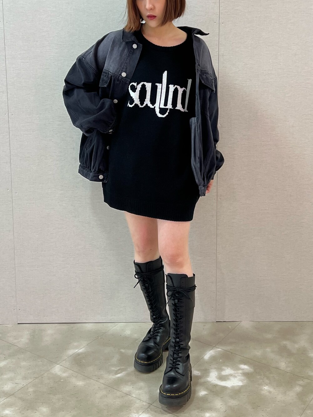 ホワイト系のニット/セーター、ブラック系のデニムジャケット、ブラック系のブーツを着用したレディースの春コーディネートの4枚目の写真