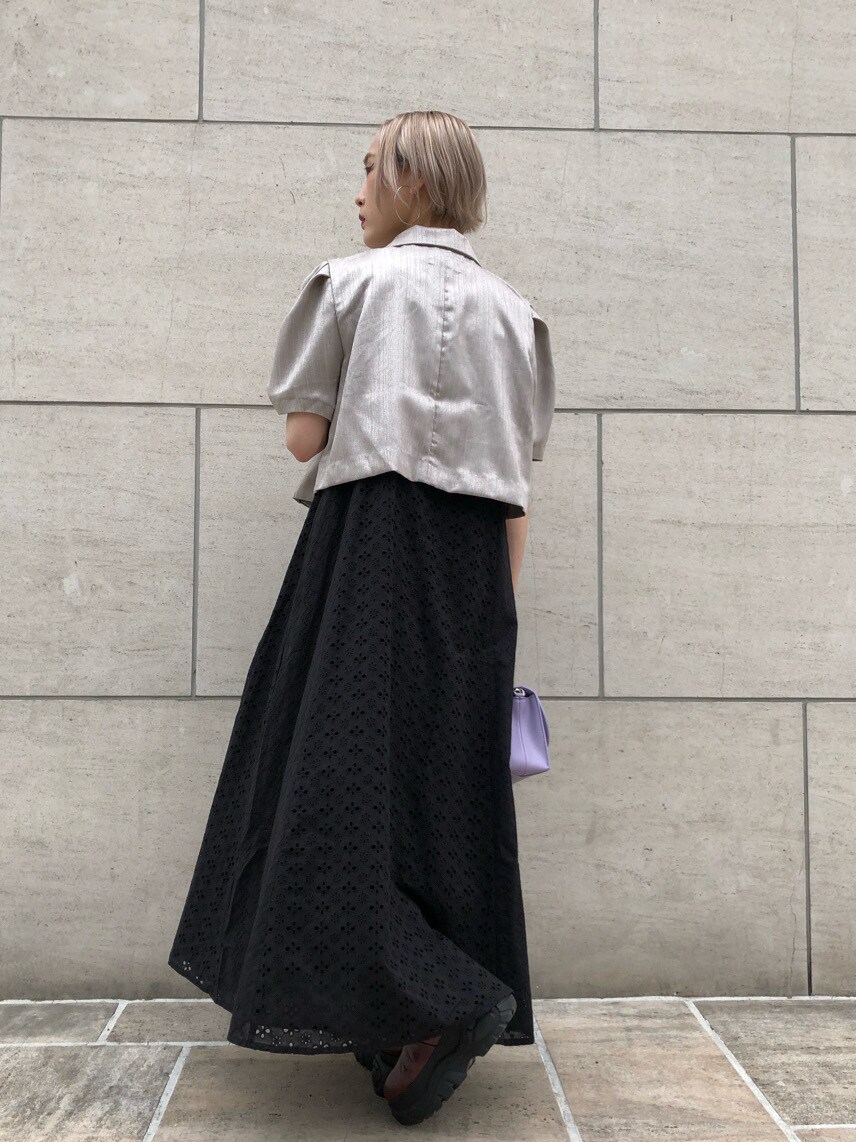 レッド系のブーツ、ホワイト系のセットアップ、ブラック系のワンピースを着用したレディースの春コーディネートの4枚目の写真