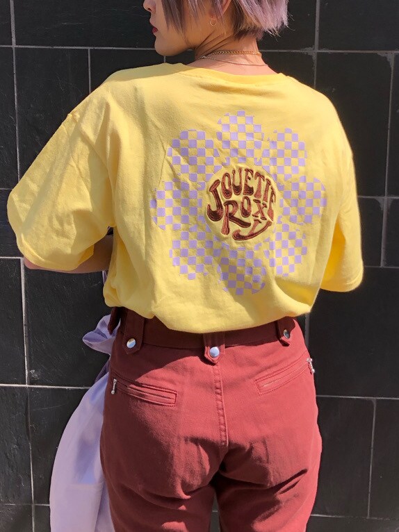 パープル系のトートバッグ、ブラウン系のデニムパンツ、イエロー系のTシャツ/カットソーを着用したレディースの春コーディネートの6枚目の写真