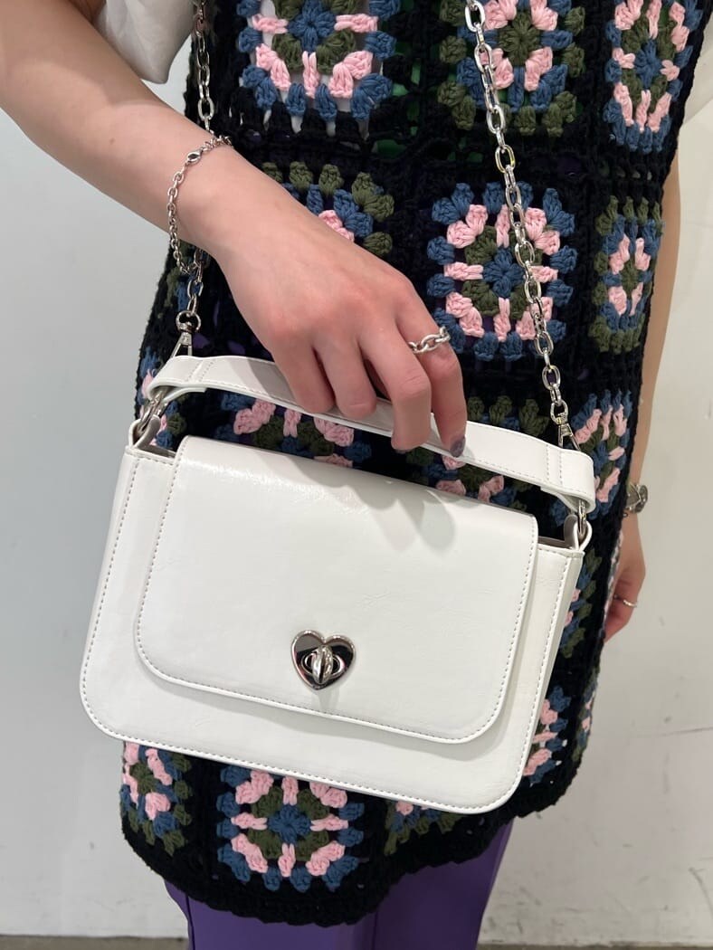 ブラック系のニット/セーター、パープル系のスラックス、ホワイト系のTシャツ/カットソーを着用したレディースの夏コーディネートの7枚目の写真