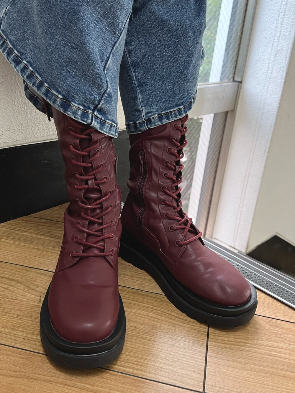 パープル系のニット/セーター、ブルー系のデニムパンツ、レッド系のブーツを着用したレディースの秋コーディネートの10枚目の写真
