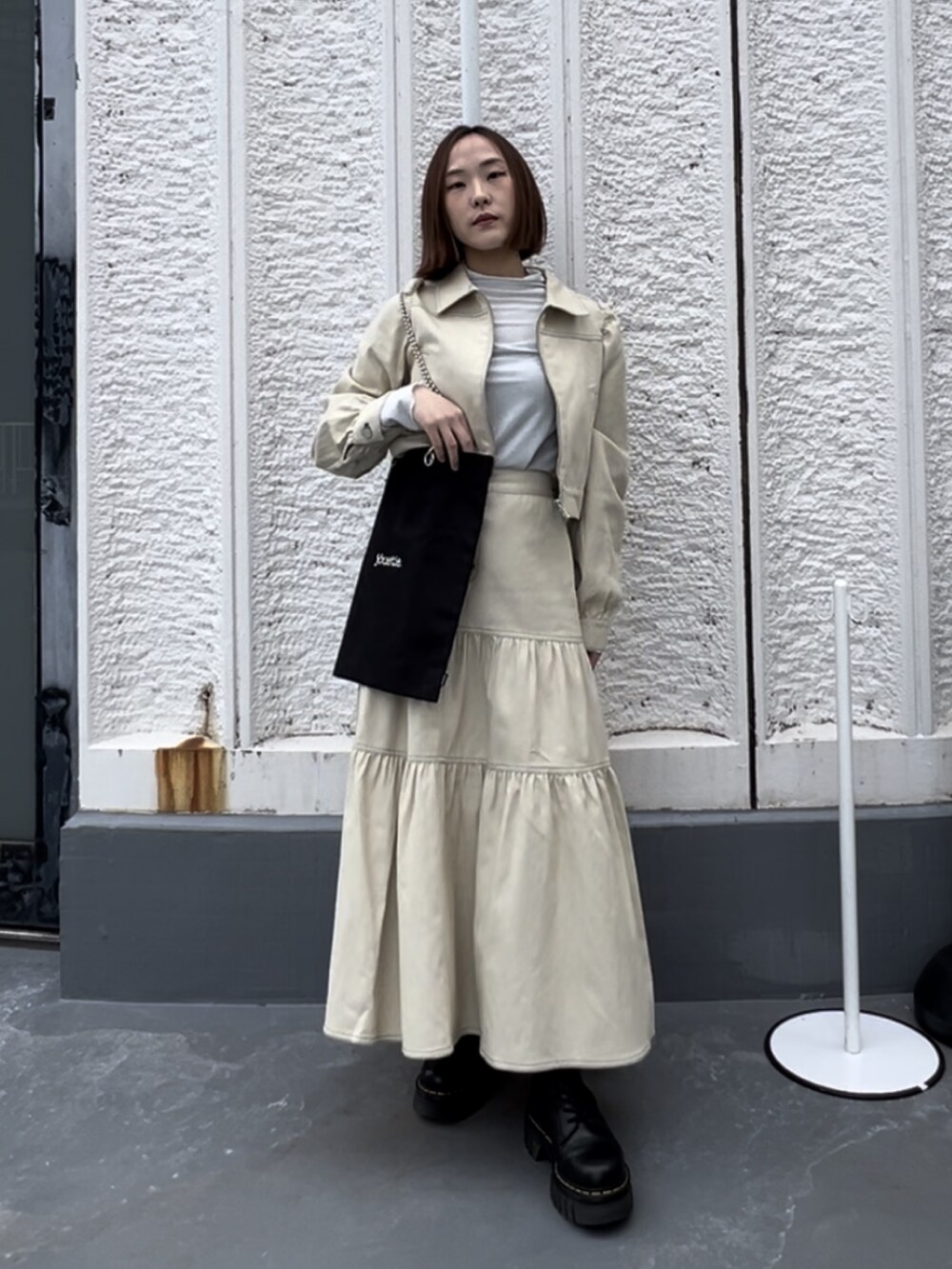 ブラック系のトートバッグ、シルバー系のTシャツ/カットソー、ブラック系のブーツを着用したレディースの春コーディネートの2枚目の写真