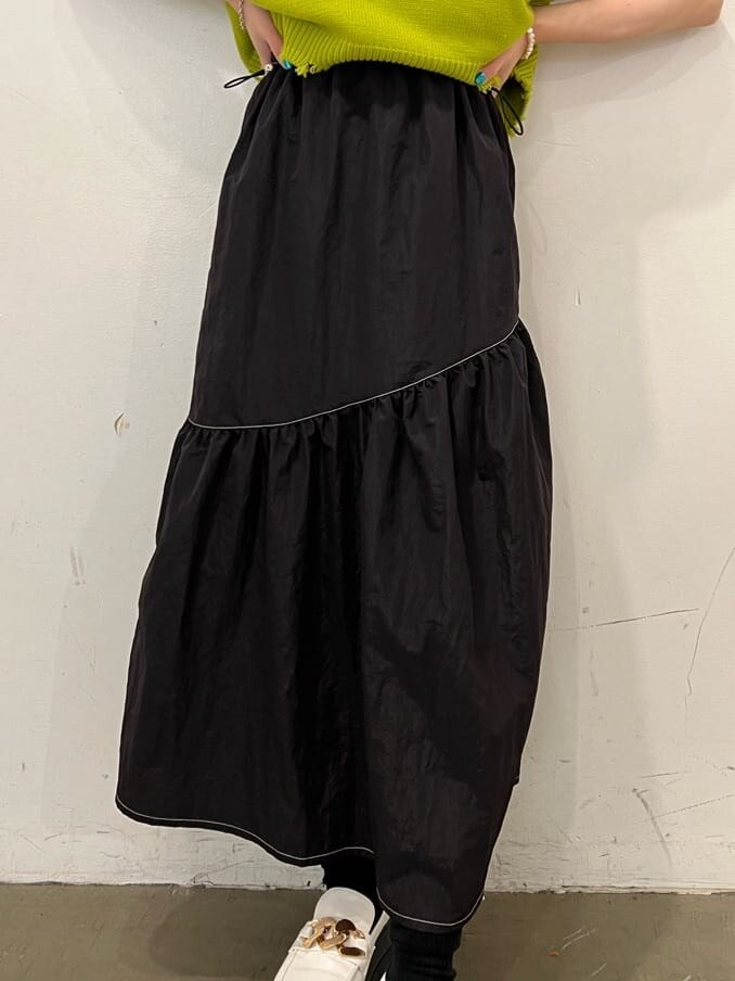 ホワイト系のローファー、グリーン系のベスト、ブラック系のジャンパースカートを着用したレディースの秋コーディネートの10枚目の写真