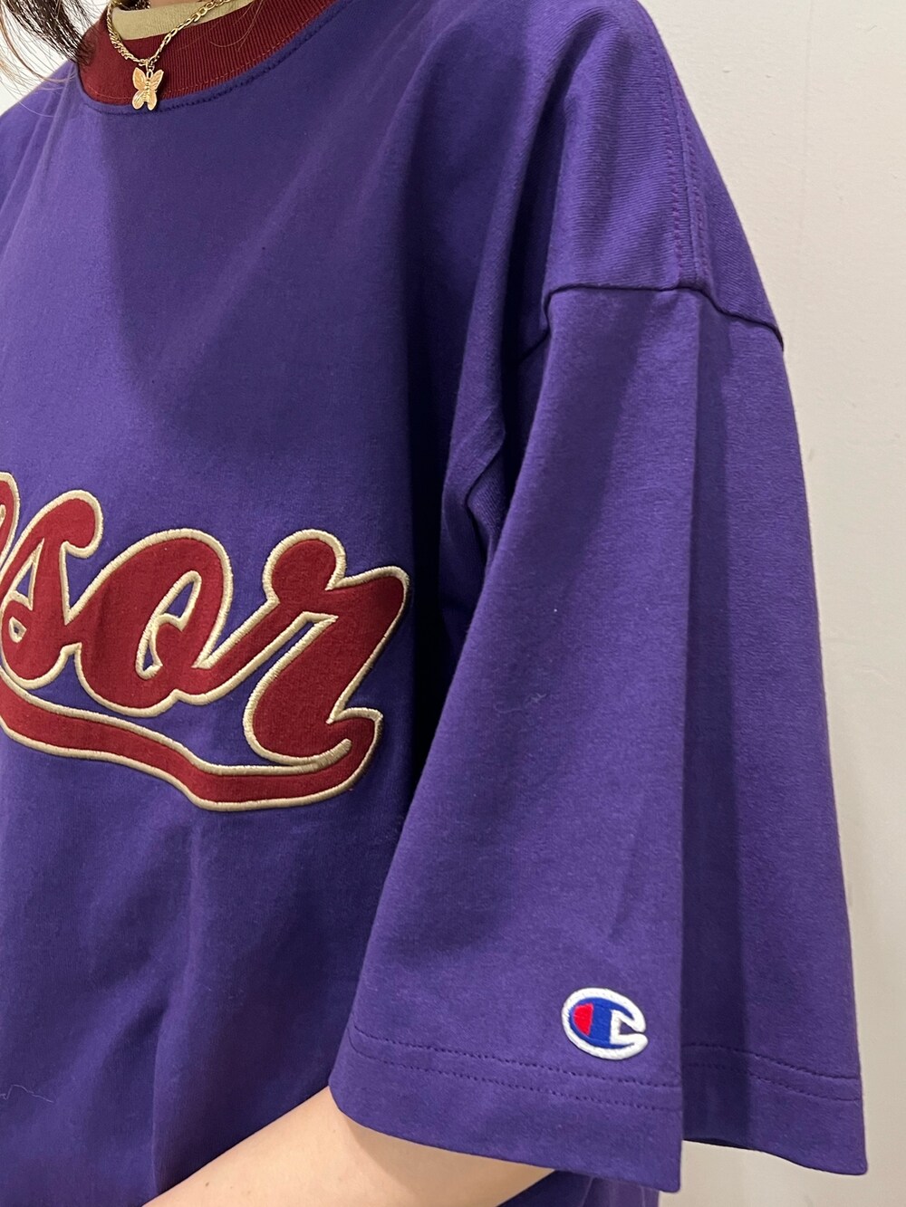 ブラック系のデニムパンツ、パープル系のTシャツ/カットソー、ホワイト系のショルダーバッグを着用したレディースの春コーディネートの6枚目の写真