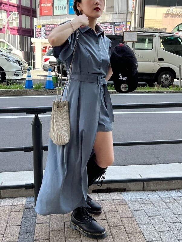 ブラック系のブーツ、グレー系のワンピース、ブラック系のキャップを着用したレディースの夏コーディネートの4枚目の写真