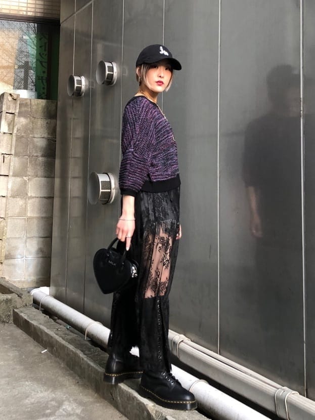 ブラック系のブーツ、ブラック系のデニムパンツ、ブラック系のショルダーバッグを着用したレディースの春コーディネートの3枚目の写真