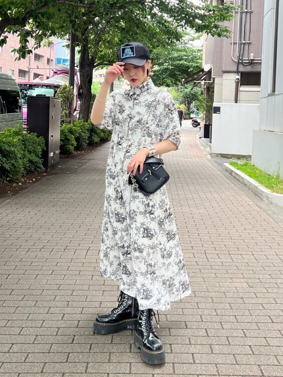 ブラック系のその他シューズ、ホワイト系のワンピース、ブラック系のキャップを着用したレディースの夏コーディネートの2枚目の写真