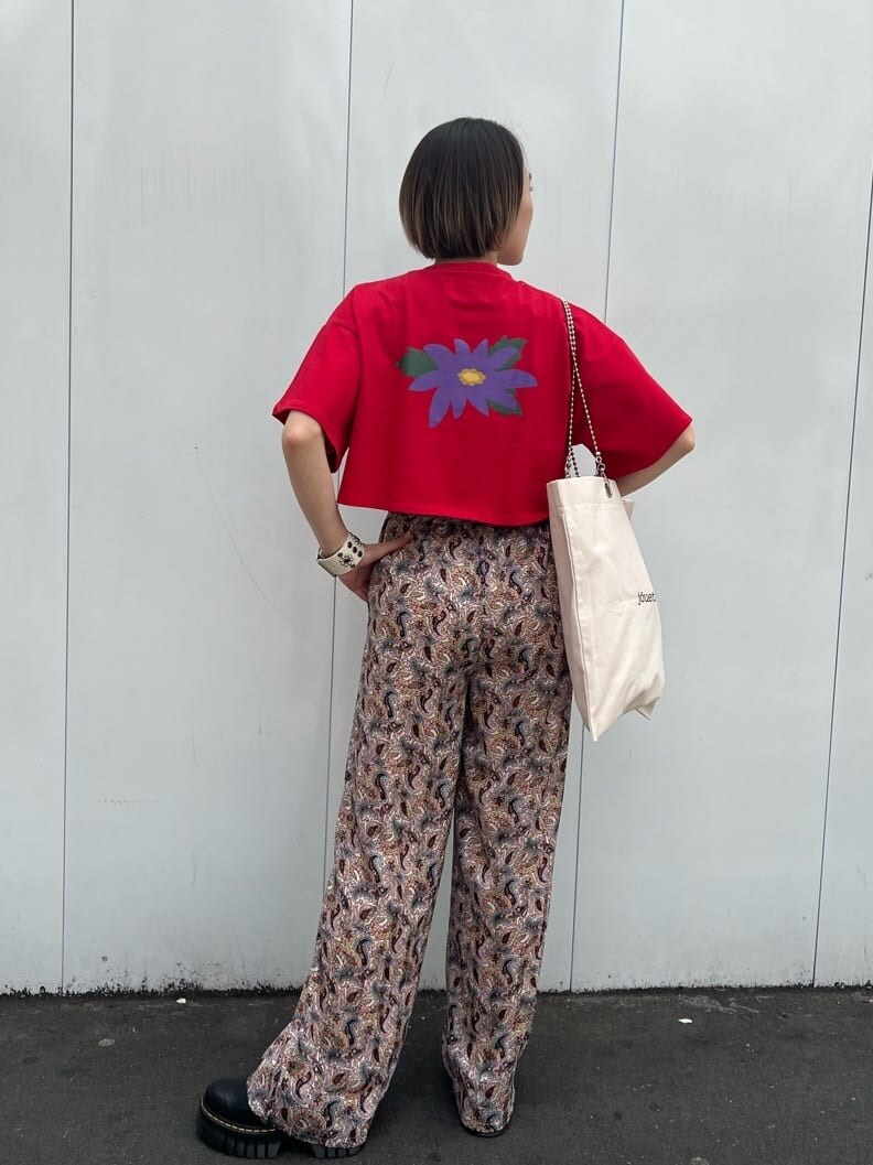 ホワイト系のトートバッグ、ブラック系のその他シューズ、レッド系のTシャツ/カットソーを着用したレディースの春コーディネートの4枚目の写真