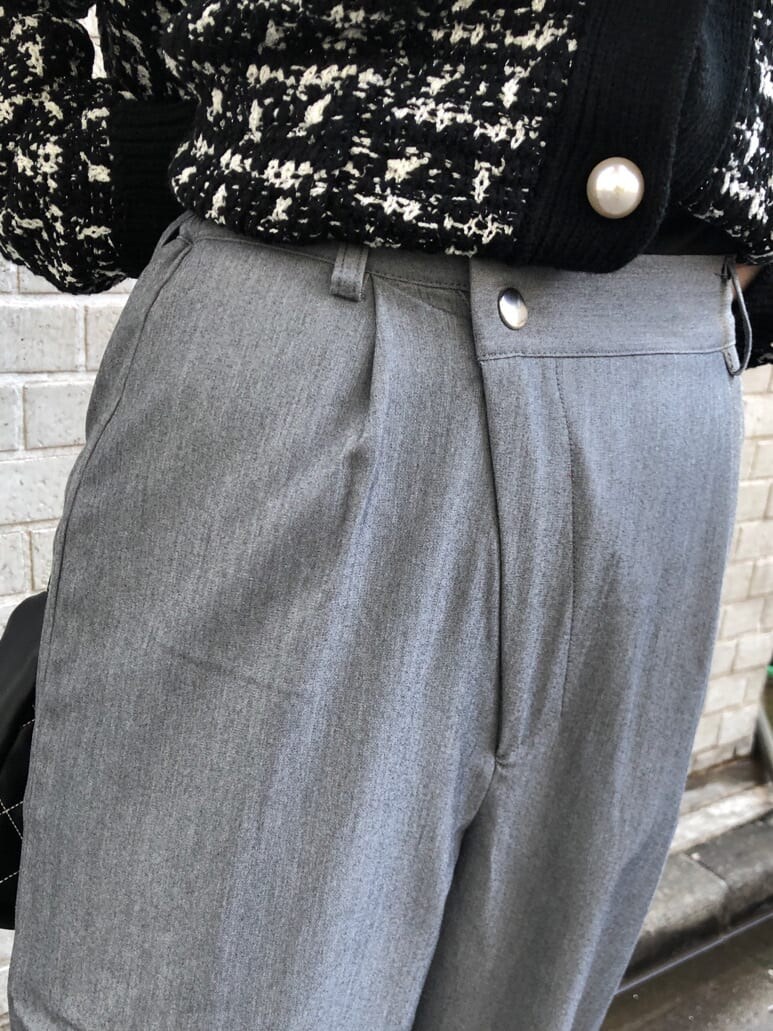 グレー系のスラックス、ブラック系のハンドバッグ、ブラック系のカーディガン/ボレロを着用したレディースの冬コーディネートの6枚目の写真