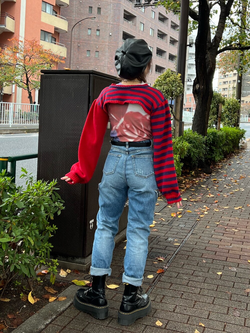 レッド系のニット/セーター、パープル系のTシャツ/カットソー、ブルー系のデニムパンツを着用したレディースの冬コーディネートの3枚目の写真