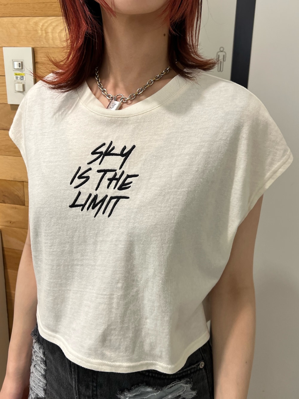 ホワイト系のタンクトップ、グリーン系のワンピース、ホワイト系のメッセンジャーバッグを着用したレディースの春コーディネートの7枚目の写真