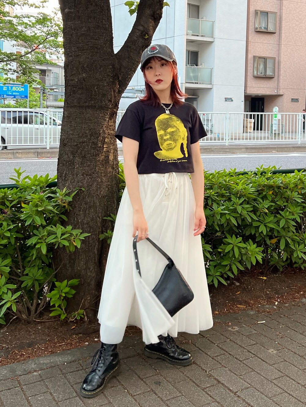 ブラック系のTシャツ/カットソー、ホワイト系のスカート、ブラック系のハンドバッグを着用したレディースの夏コーディネートの5枚目の写真