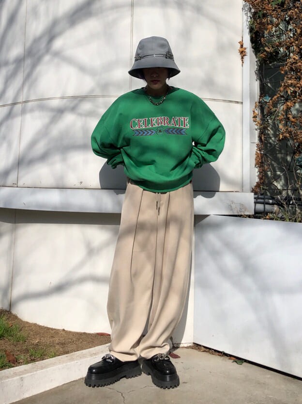 ホワイト系のスラックス、グリーン系のスウェットを着用したレディースの冬コーディネートの2枚目の写真