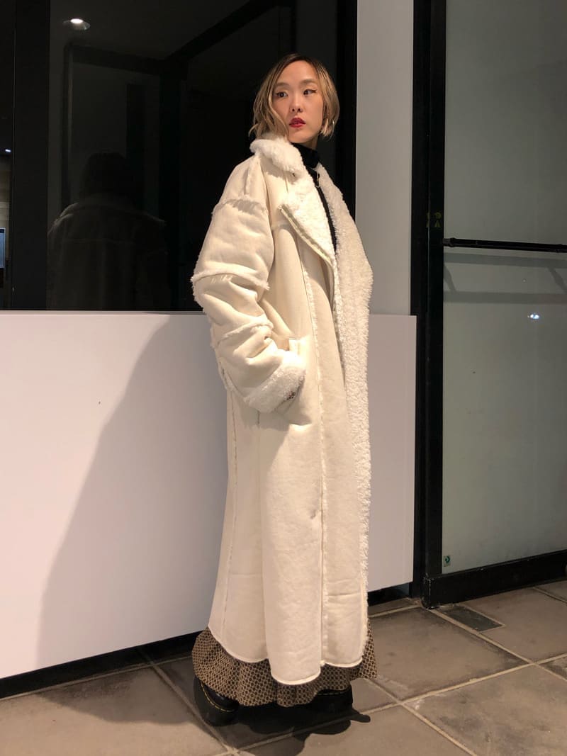 ホワイト系のムートンコート、その他のスカート、ブラック系のカーディガン/ボレロを着用したレディースの秋コーディネートの3枚目の写真