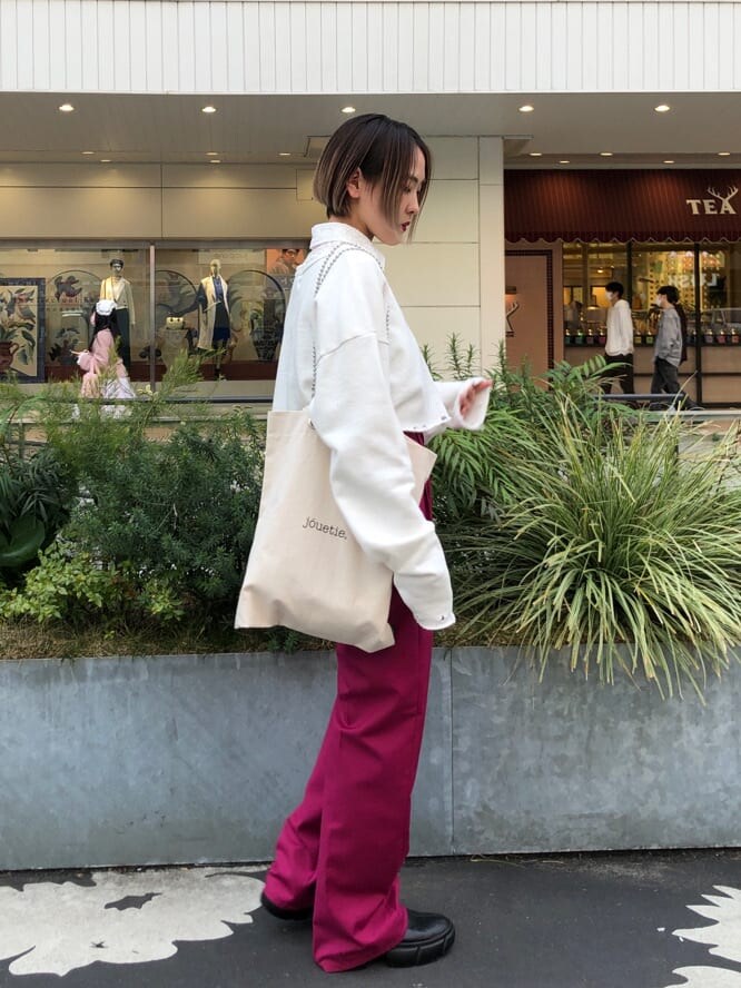 ピンク系のスラックス、ホワイト系のトートバッグ、ブラック系のブーツを着用したレディースの春コーディネートの4枚目の写真