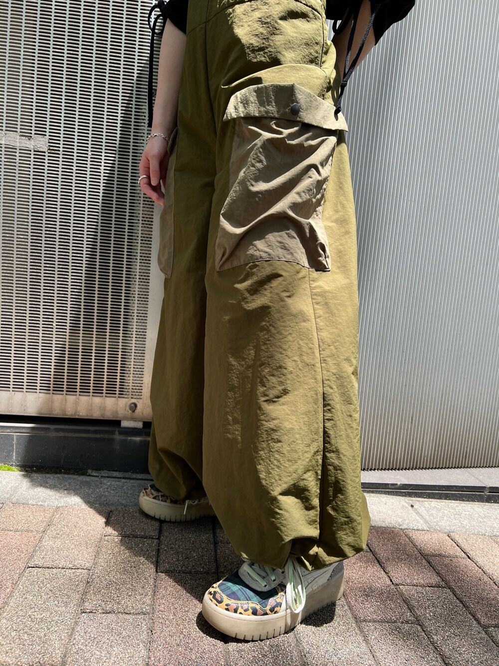 ブラック系のTシャツ/カットソー、グリーン系のサロペット/オーバーオールを着用したレディースの夏コーディネートの9枚目の写真