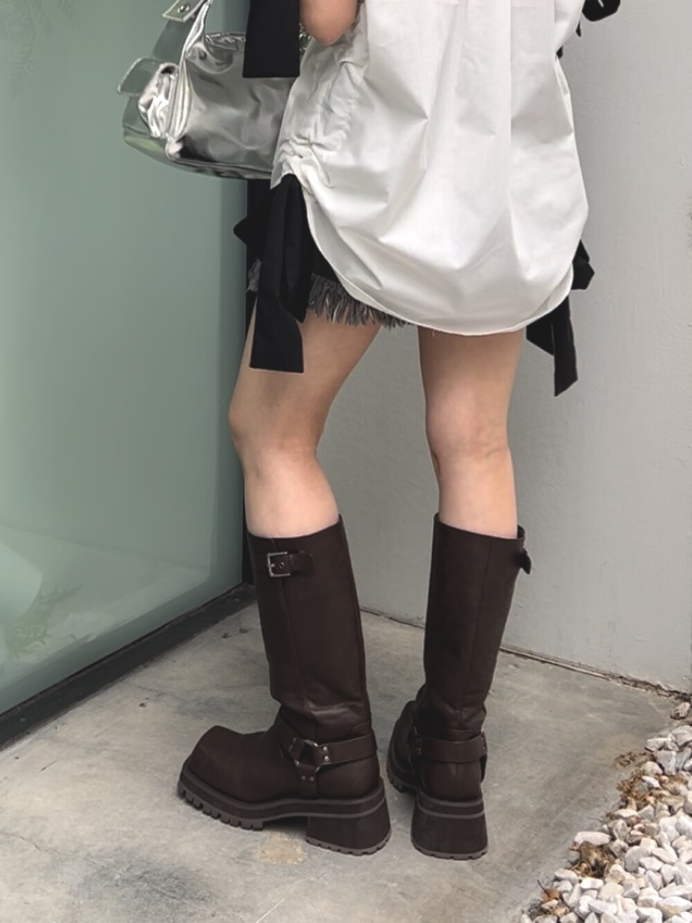 ホワイト系のシャツ/ブラウス、シルバー系のハンドバッグ、ブラック系のデニムパンツを着用したレディースの夏コーディネートの6枚目の写真