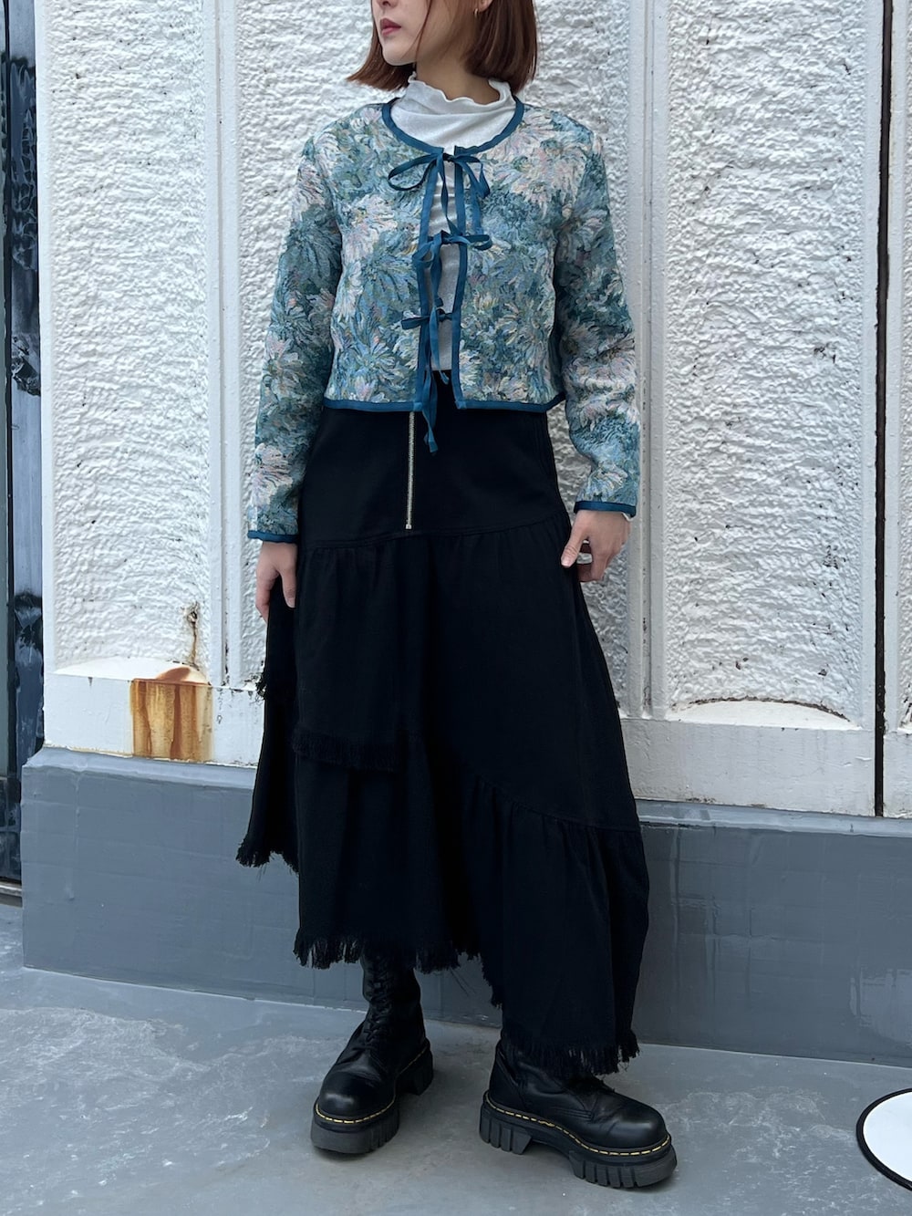 ブルー系のノーカラージャケット、ホワイト系のスカート、シルバー系のTシャツ/カットソーを着用したレディースの春コーディネートの6枚目の写真