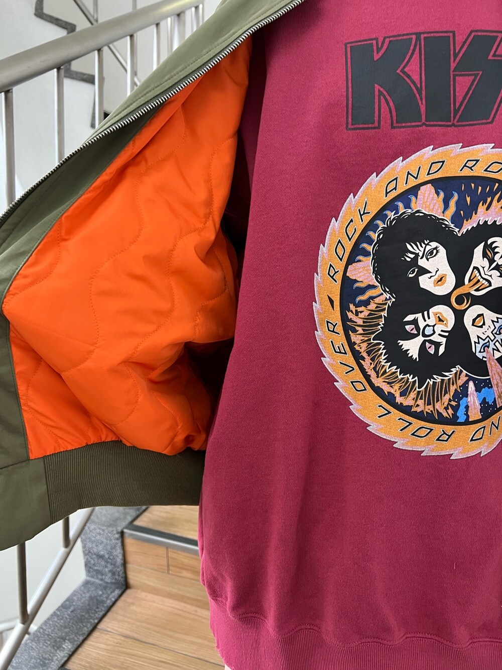 レッド系のスウェット、グリーン系のMA-1、ブラック系のデニムパンツを着用したレディースの冬コーディネートの7枚目の写真