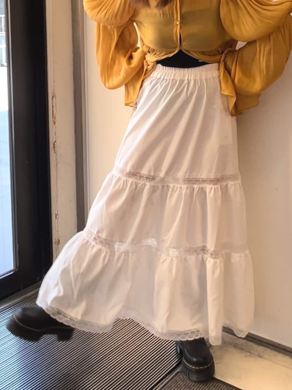 オレンジ系のシャツ/ブラウス、ホワイト系のスカート、ホワイト系のショルダーバッグを着用したレディースの春コーディネートの8枚目の写真