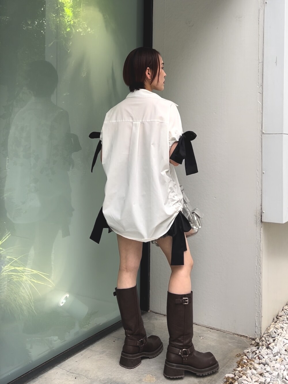 ホワイト系のシャツ/ブラウス、シルバー系のハンドバッグ、ブラック系のデニムパンツを着用したレディースの夏コーディネートの4枚目の写真