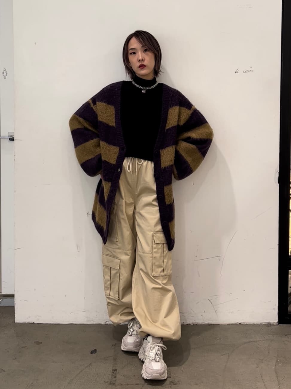 パープル系のカーディガン/ボレロ、ホワイト系のカーゴパンツ、ブラック系のスウェットを着用したレディースの秋コーディネートの5枚目の写真
