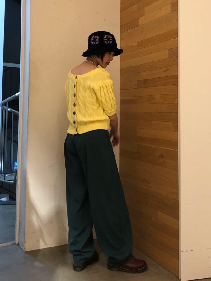 グリーン系のスラックス、イエロー系のニット/セーター、シルバー系のネックレスを着用したレディースの冬コーディネートの3枚目の写真