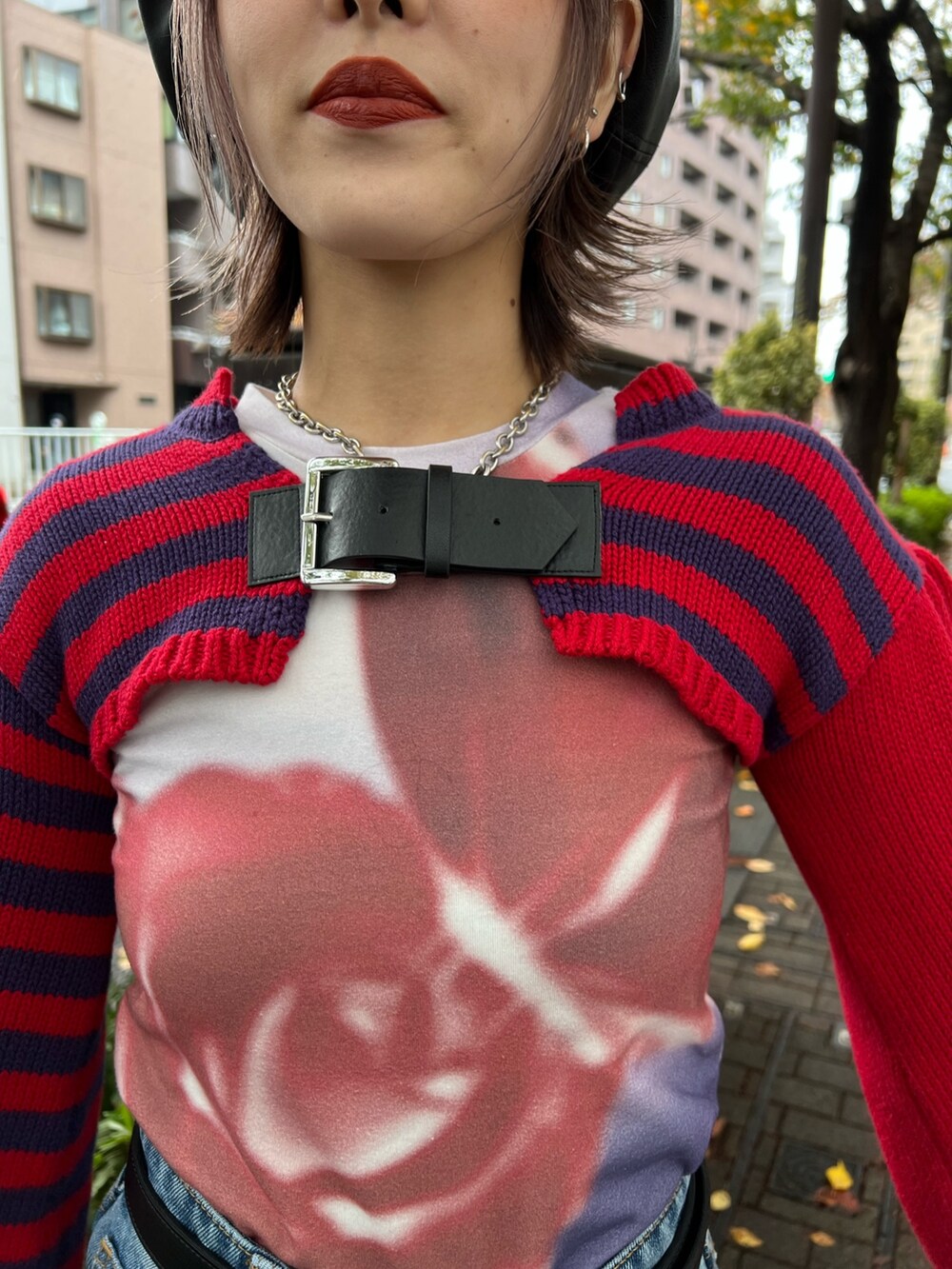 レッド系のニット/セーター、パープル系のTシャツ/カットソー、ブルー系のデニムパンツを着用したレディースの冬コーディネートの6枚目の写真