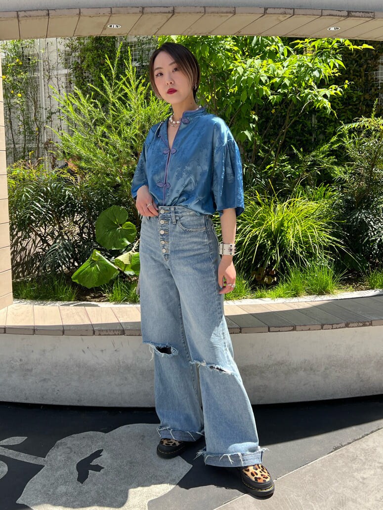 ブルー系のデニムパンツ、ホワイト系のキャミソール、ブルー系のシャツ/ブラウスを着用したレディースの春コーディネートの2枚目の写真