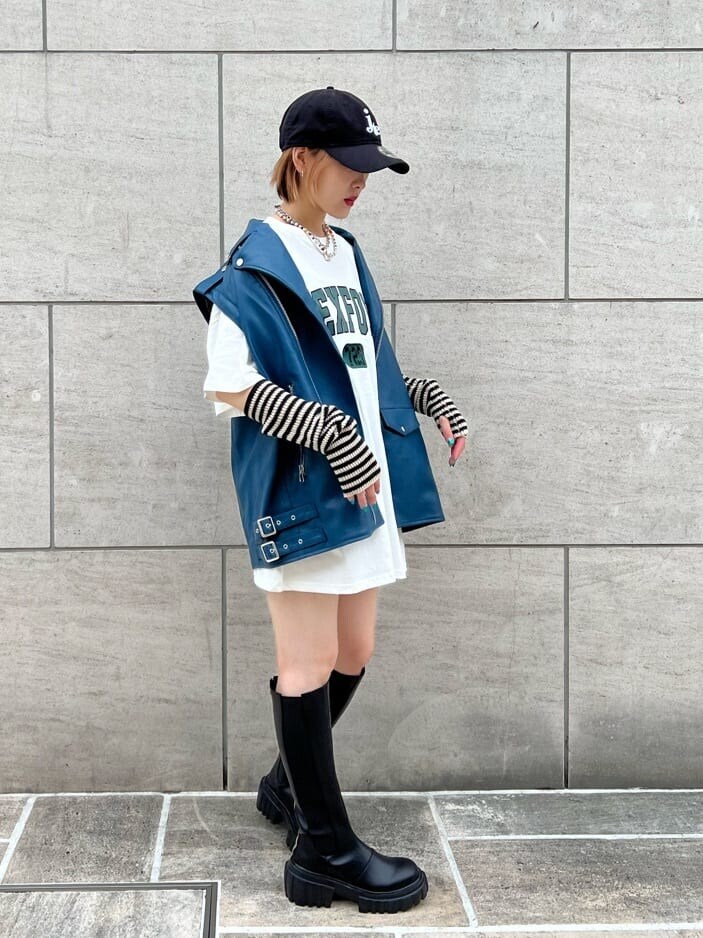 ブラック系のデニムパンツ、ホワイト系のTシャツ/カットソー、ブラック系のブーツを着用したレディースの秋コーディネートの3枚目の写真