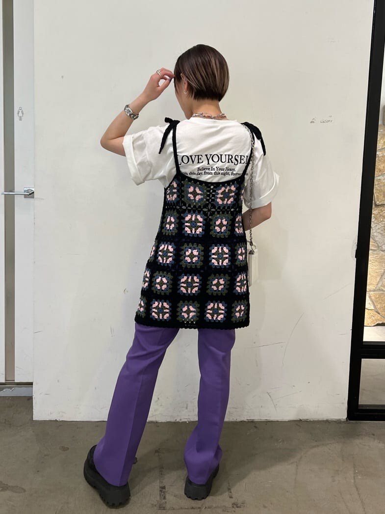 ブラック系のニット/セーター、パープル系のスラックス、ホワイト系のTシャツ/カットソーを着用したレディースの夏コーディネートの2枚目の写真