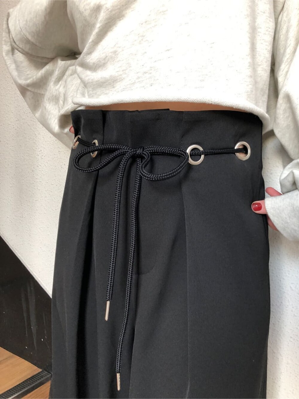 ブラック系のスラックス、グレー系のTシャツ/カットソー、ホワイト系のスニーカーを着用したレディースの冬コーディネートの7枚目の写真