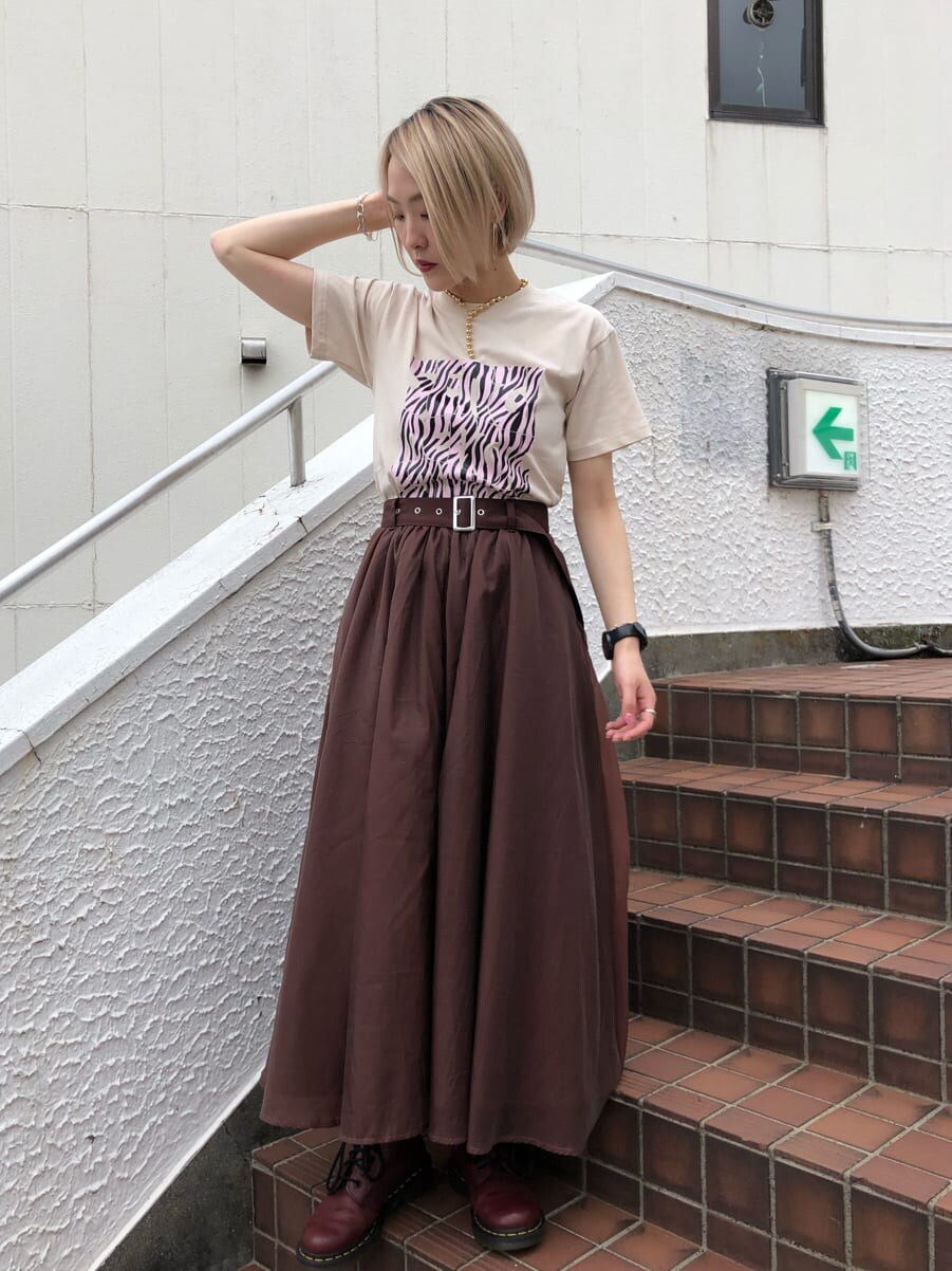 ブラウン系のスカート、ホワイト系のTシャツ/カットソー、ゴールド系のチョーカーを着用したレディースの夏コーディネートの2枚目の写真