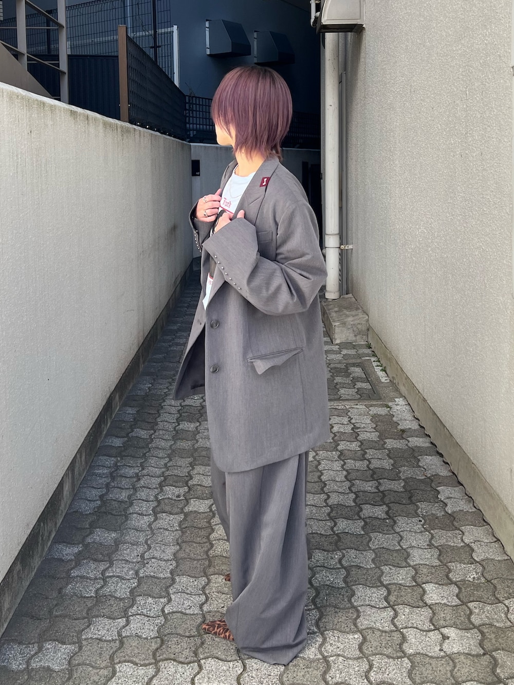 グレー系のテーラードジャケット、グレー系のスラックス、ブルー系のTシャツ/カットソーを着用したレディースの春コーディネートの5枚目の写真