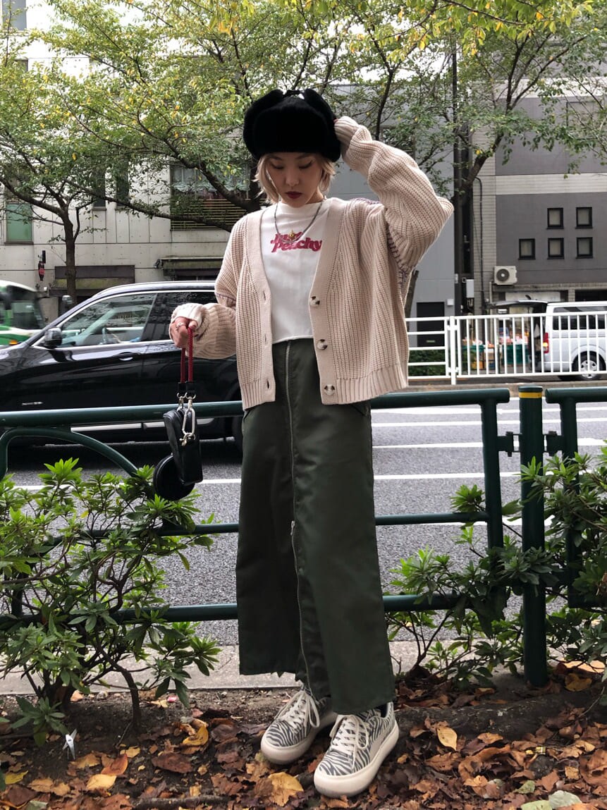 ブラック系のショルダーバッグ、ベージュ系のワンピース、ホワイト系のカーディガン/ボレロを着用したレディースの秋コーディネートの4枚目の写真