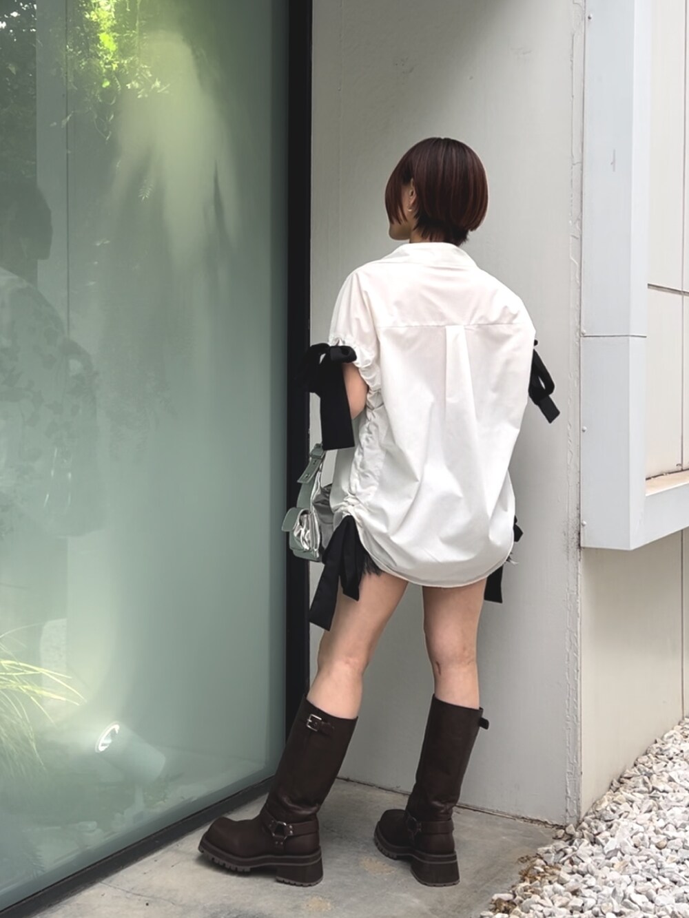 ホワイト系のシャツ/ブラウス、シルバー系のハンドバッグ、ブラック系のデニムパンツを着用したレディースの夏コーディネートの5枚目の写真