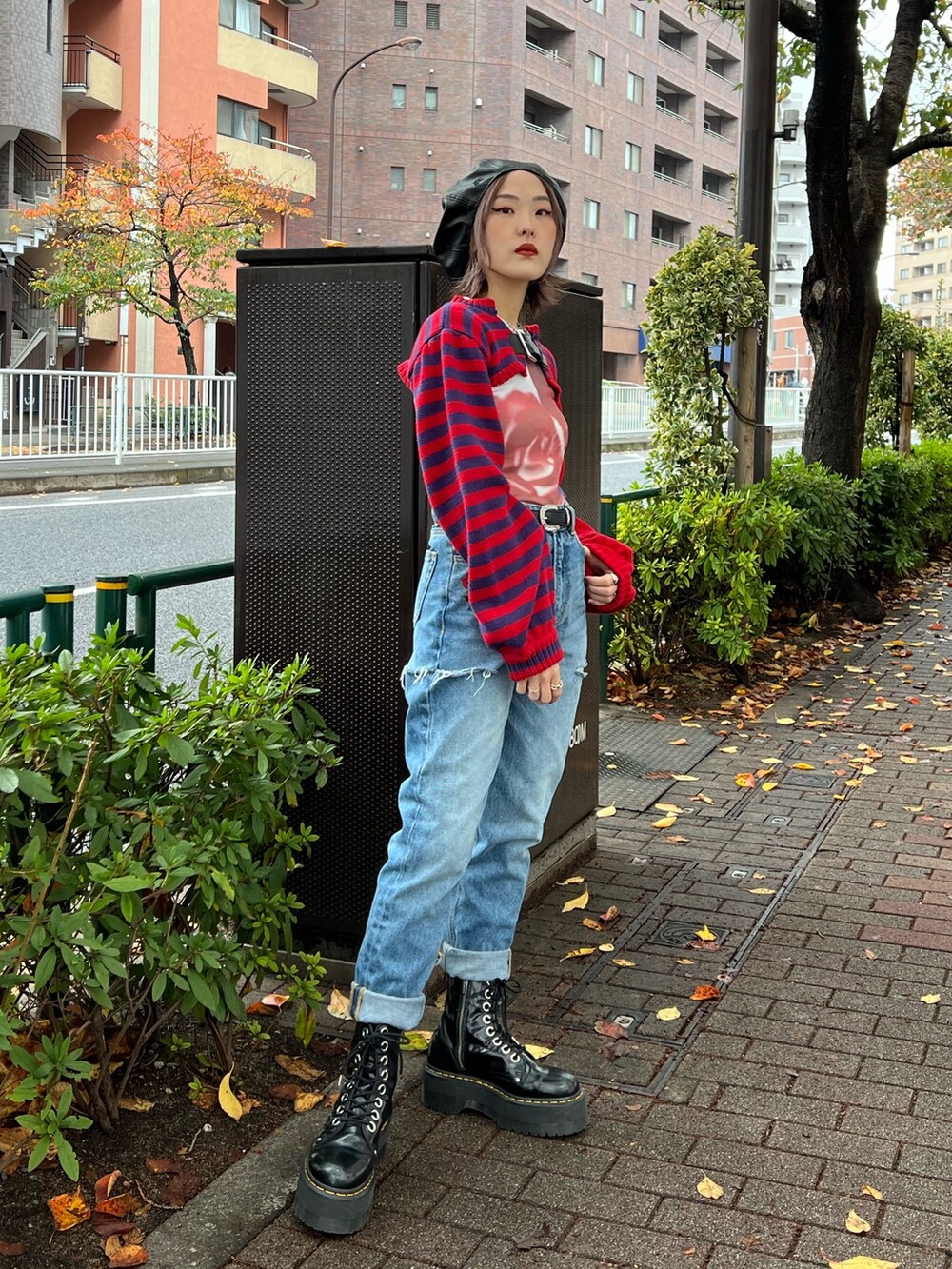 レッド系のニット/セーター、パープル系のTシャツ/カットソー、ブルー系のデニムパンツを着用したレディースの冬コーディネートの4枚目の写真