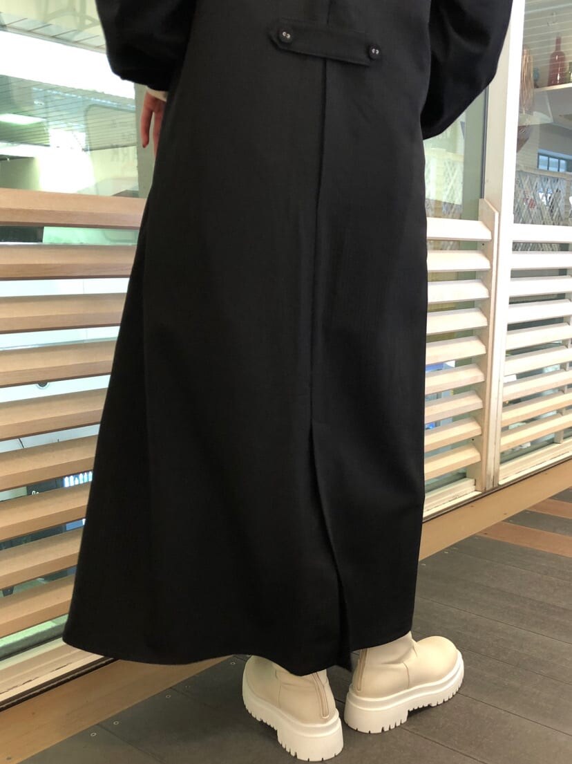 ホワイト系のシャツ/ブラウス、ブラック系のジャンパースカート、ホワイト系のブーツを着用したレディースの春コーディネートの7枚目の写真