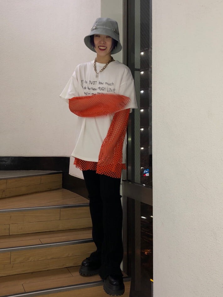 ブラック系のその他パンツ、オレンジ系のTシャツ/カットソー、ホワイト系のTシャツ/カットソーを着用したレディースの冬コーディネートの7枚目の写真