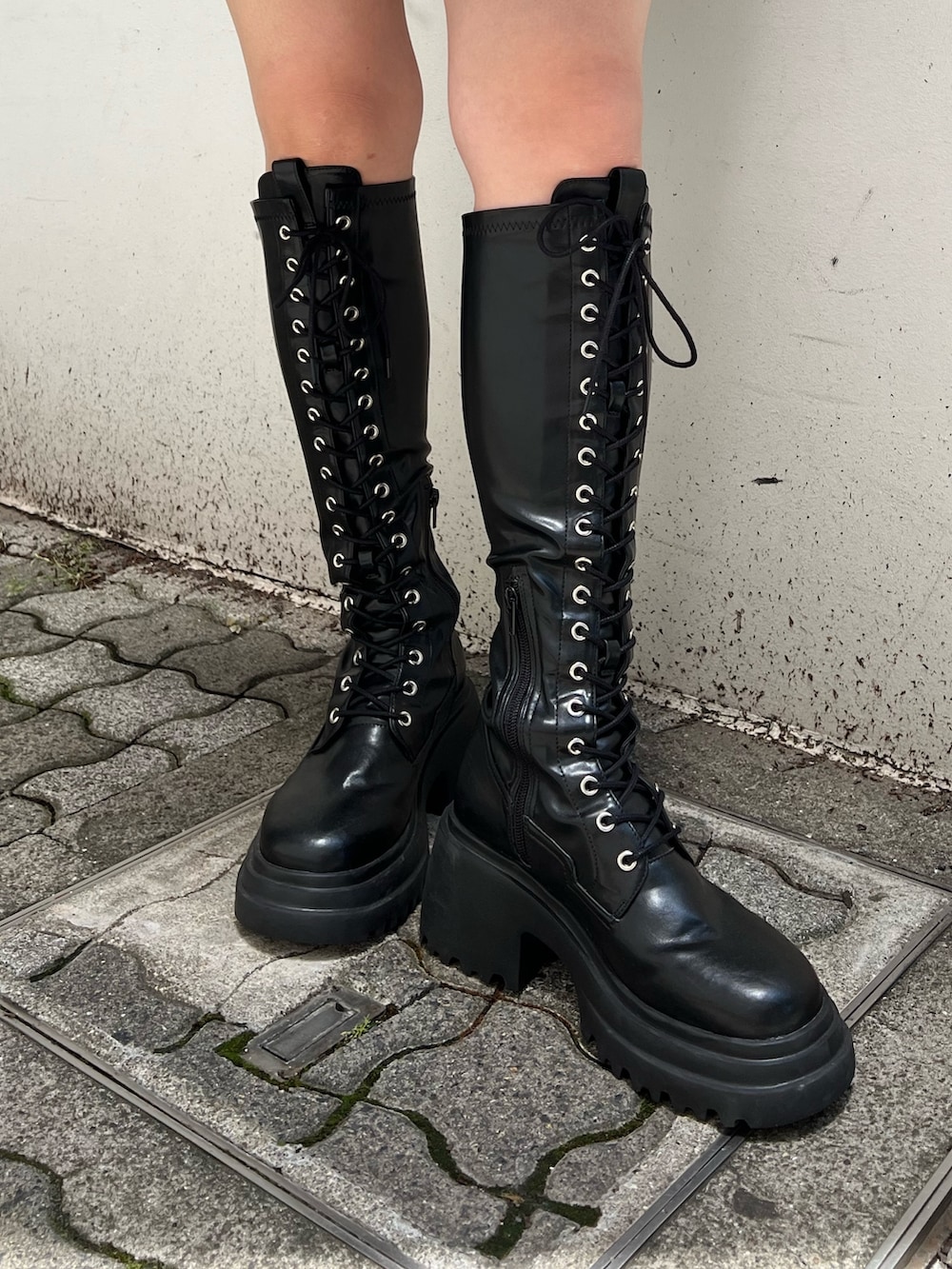 グレー系のワンピース、ブラック系のブーツを着用したレディースの夏コーディネートの7枚目の写真